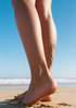 Close-up of legs on a beach with a clear blue sky SKINBUFFS